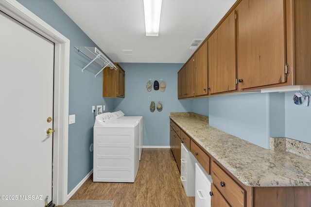 65535 E Rose Ridge Dr, Saddlebrooke, AZ 85739 - laundry area with cabinet space, wood finished floors, separate washer and dryer, and baseboards