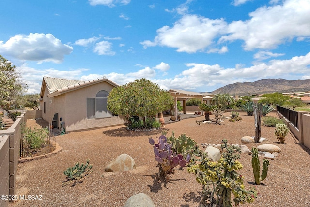 65535 E Rose Ridge Dr, Saddlebrooke, AZ 85739 - view of front facade featuring stucco siding, a fenced backyard, a tile roof, a mountain view, and a patio area