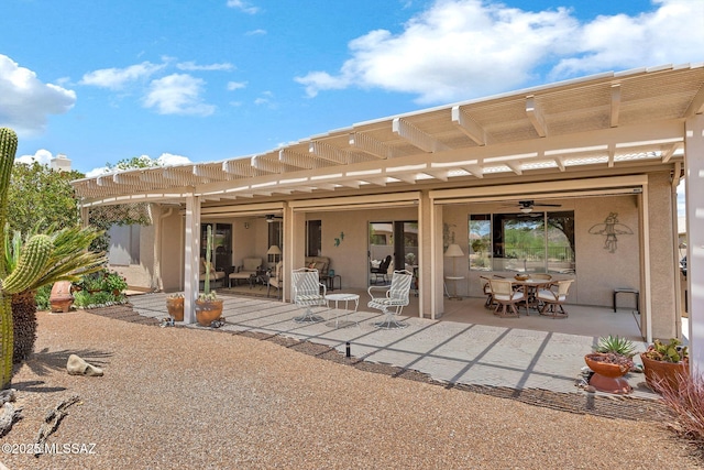 65535 E Rose Ridge Dr, Saddlebrooke, AZ 85739 - back of property featuring ceiling fan, outdoor dining area, stucco siding, and a patio