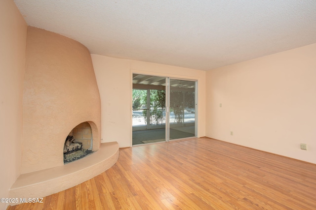 4736 N Calle Lampara, Tucson, AZ 85718 - unfurnished living room featuring wood finished floors and a fireplace