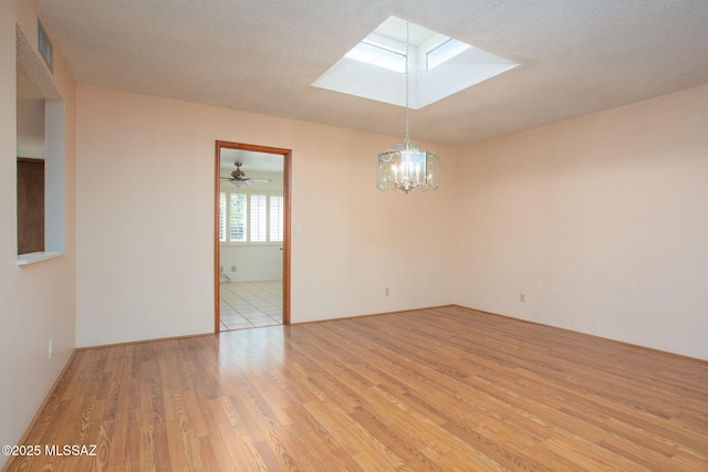 4736 N Calle Lampara, Tucson, AZ 85718 - spare room with a skylight, light wood-style flooring, and a chandelier