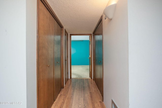 4736 N Calle Lampara, Tucson, AZ 85718 - corridor featuring a textured ceiling and light wood-type flooring
