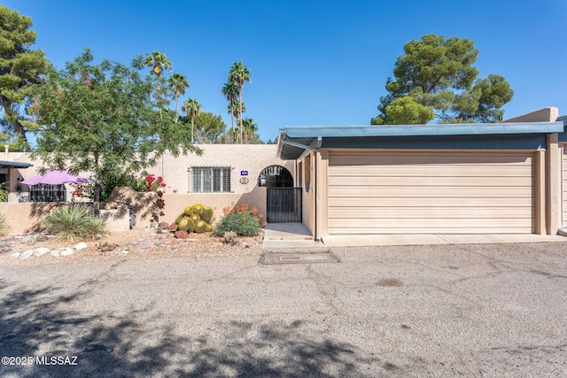 4736 N Calle Lampara, Tucson, AZ 85718 - view of front facade with an attached garage, stucco siding, and driveway