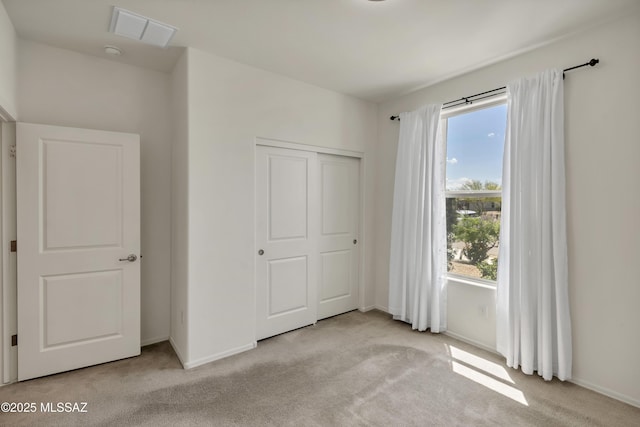 9569 N Sage Vista Ct, Tucson, AZ 85742 - unfurnished bedroom featuring carpet flooring, multiple windows, baseboards, and a closet