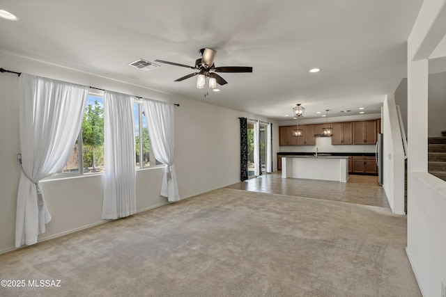 9569 N Sage Vista Ct, Tucson, AZ 85742 - unfurnished living room with recessed lighting, stairway, a ceiling fan, a sink, and light carpet
