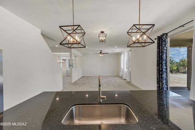 9569 N Sage Vista Ct, Tucson, AZ 85742 - kitchen featuring a sink, a chandelier, ceiling fan, dark stone countertops, and hanging light fixtures