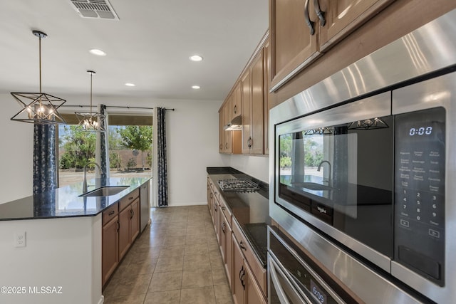 9569 N Sage Vista Ct, Tucson, AZ 85742 - kitchen featuring a sink, under cabinet range hood, a kitchen island with sink, recessed lighting, and dark stone counters