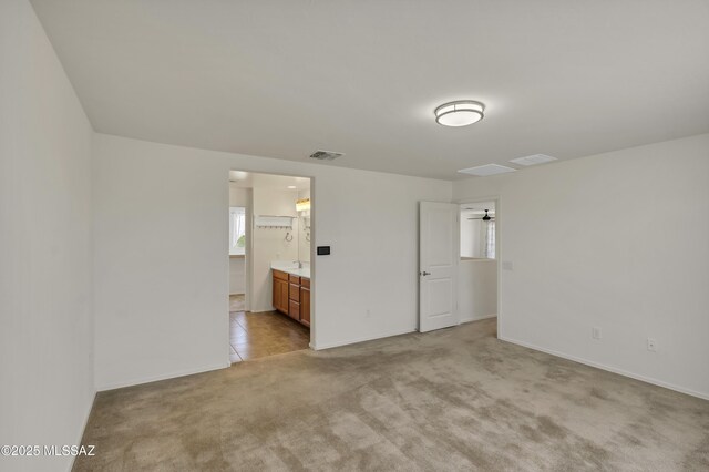 9569 N Sage Vista Ct, Tucson, AZ 85742 - unfurnished bedroom featuring light carpet, baseboards, and connected bathroom