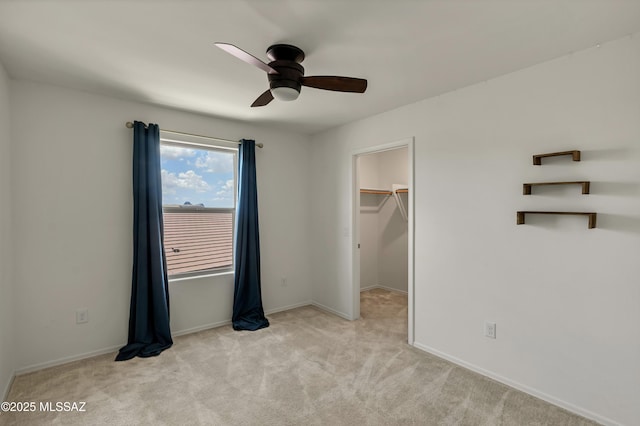 9569 N Sage Vista Ct, Tucson, AZ 85742 - unfurnished bedroom with light colored carpet, a walk in closet, and baseboards