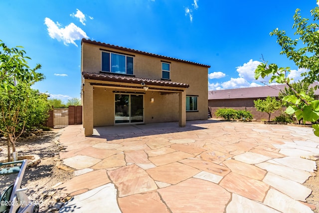 9569 N Sage Vista Ct, Tucson, AZ 85742 - rear view of property featuring a tiled roof, stucco siding, a fenced backyard, and a gate