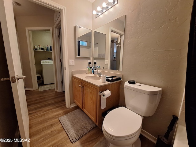 4396 S Valley Rd, Tucson, AZ 85714 - bathroom with washer / dryer, wood finished floors, vanity, toilet, and a textured wall