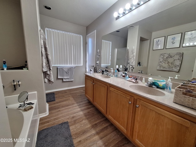 4396 S Valley Rd, Tucson, AZ 85714 - bathroom featuring double vanity, a bath, wood finished floors, and baseboards