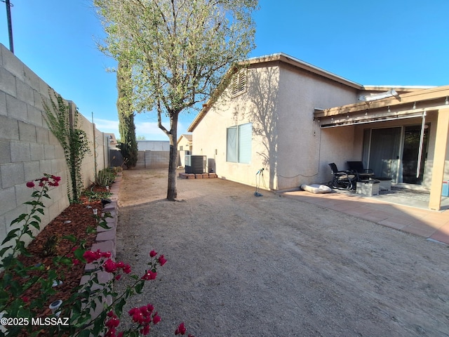 4396 S Valley Rd, Tucson, AZ 85714 - view of side of home with central air condition unit, stucco siding, a fenced backyard, and a patio