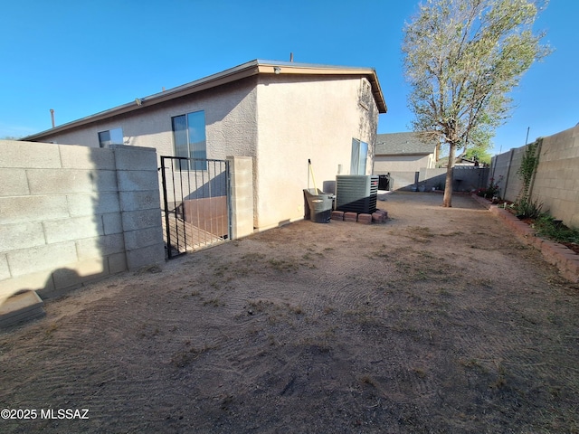 4396 S Valley Rd, Tucson, AZ 85714 - view of property exterior featuring a gate, a fenced backyard, stucco siding, and cooling unit