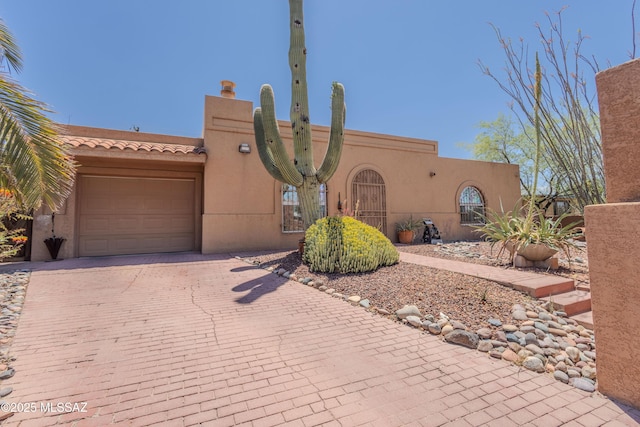 5457 S 13th Ave, Tucson, AZ 85706 - pueblo revival-style home featuring decorative driveway, stucco siding, and a garage