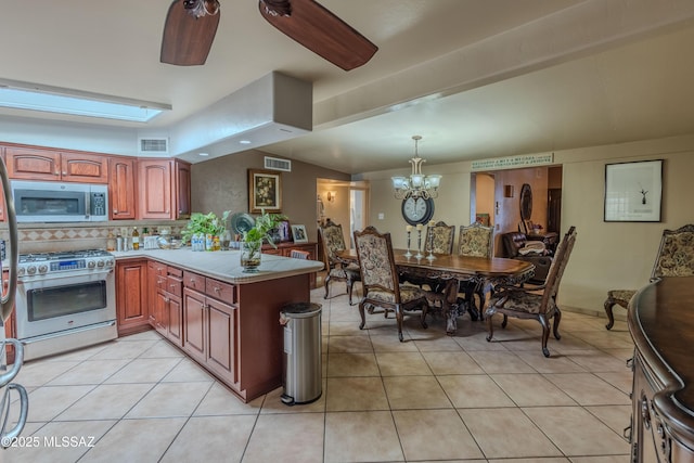 5457 S 13th Ave, Tucson, AZ 85706 - kitchen with stainless steel appliances, a peninsula, light countertops, and light tile patterned floors