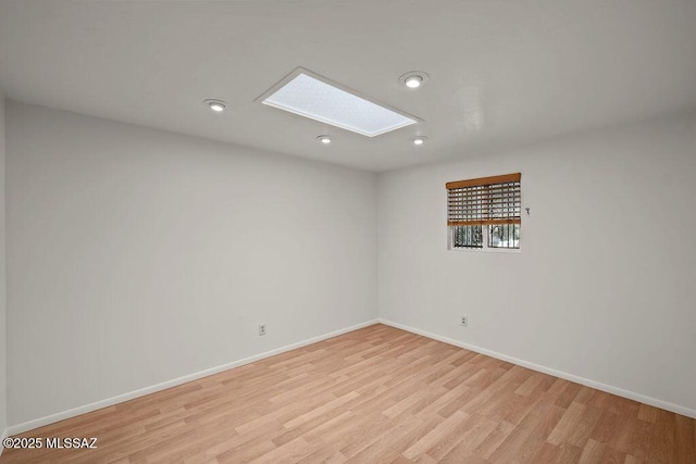 8069 E Cameo Cir, Tucson, AZ 85750 - empty room with light wood-type flooring, a skylight, baseboards, and recessed lighting