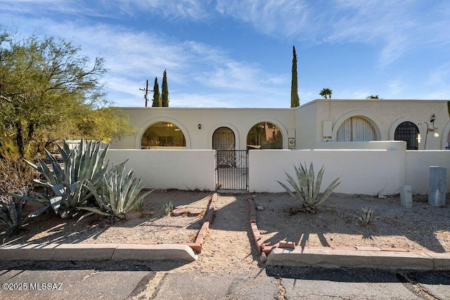 8069 E Cameo Cir, Tucson, AZ 85750 - view of front of home featuring a fenced front yard, stucco siding, and a gate