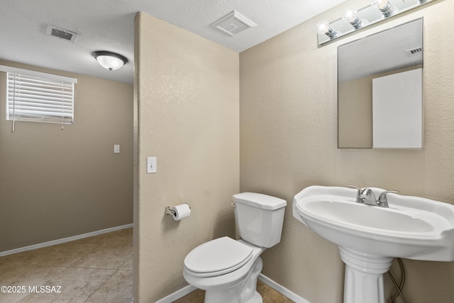6783 W Alegria Dr, Tucson, AZ 85743 - bathroom featuring toilet, baseboards, and tile patterned flooring