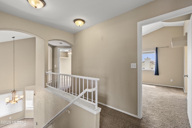 6783 W Alegria Dr, Tucson, AZ 85743 - corridor featuring an upstairs landing, a chandelier, carpet floors, arched walkways, and baseboards