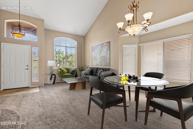 6783 W Alegria Dr, Tucson, AZ 85743 - dining room with high vaulted ceiling, a chandelier, carpet floors, and baseboards