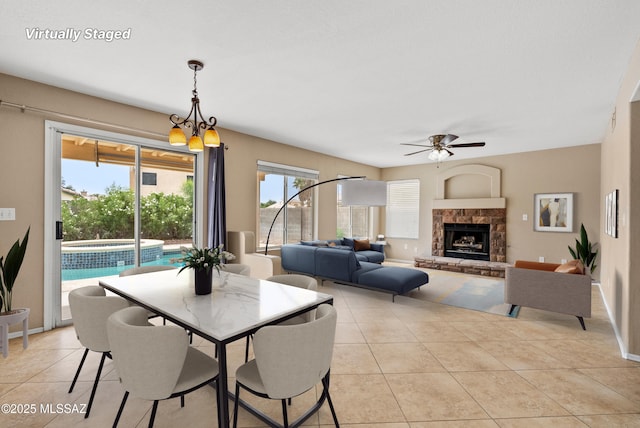 6783 W Alegria Dr, Tucson, AZ 85743 - dining area featuring a ceiling fan, light tile patterned floors, a fireplace, and baseboards