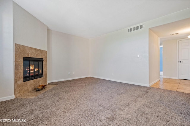 6651 N Campbell Ave Apt 221, Tucson, AZ 85718 - unfurnished living room with carpet flooring, a tile fireplace, and baseboards