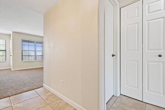 6651 N Campbell Ave Apt 221, Tucson, AZ 85718 - hallway with light colored carpet, light tile patterned flooring, and baseboards