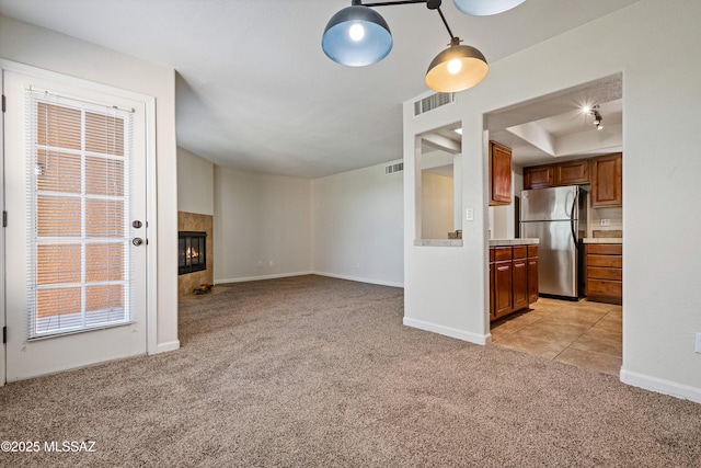 6651 N Campbell Ave Apt 221, Tucson, AZ 85718 - unfurnished living room with light carpet, a fireplace, baseboards, and a tray ceiling