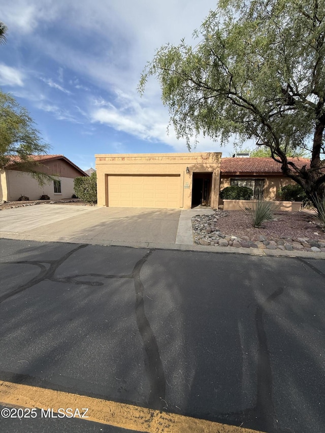 5640 N Placita Favorita, Tucson, AZ 85750 - view of front facade with an attached garage, concrete driveway, and stucco siding