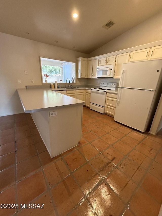 5640 N Placita Favorita, Tucson, AZ 85750 - kitchen with white appliances, a peninsula, lofted ceiling, white cabinetry, and a sink