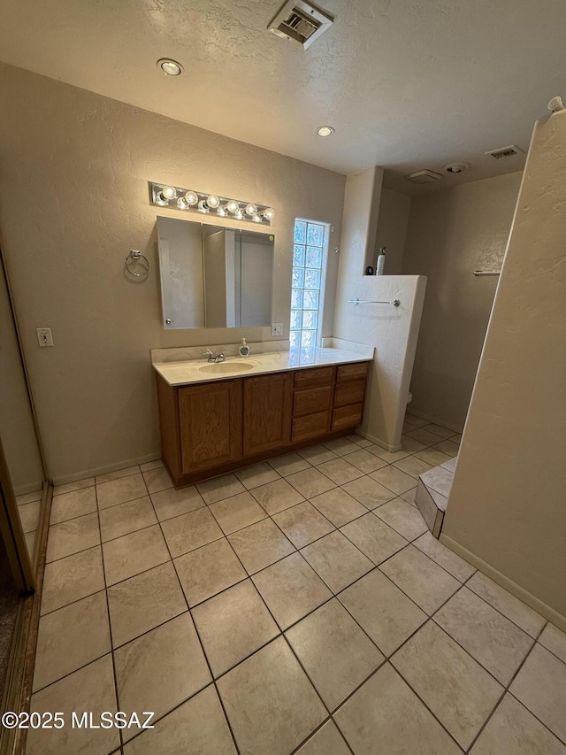 5640 N Placita Favorita, Tucson, AZ 85750 - bathroom featuring vanity, tile patterned floors, toilet, a textured ceiling, and a textured wall