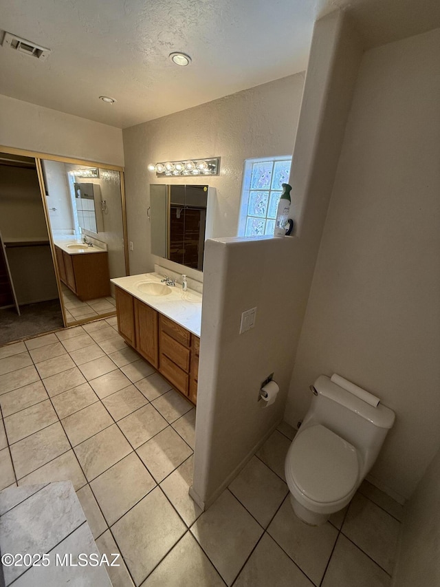 5640 N Placita Favorita, Tucson, AZ 85750 - bathroom featuring toilet, tile patterned floors, vanity, and a textured ceiling