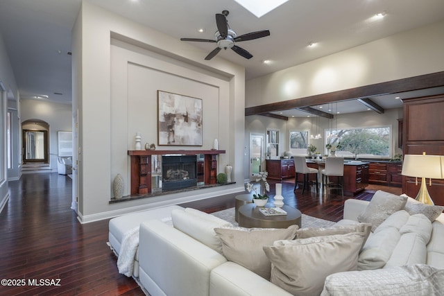3750 E Sumo Quinto, Tucson, AZ 85718 - living area with dark wood finished floors, a ceiling fan, a glass covered fireplace, arched walkways, and recessed lighting