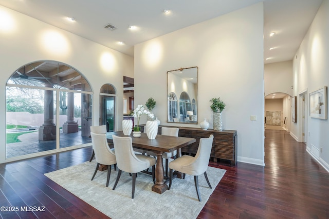 3750 E Sumo Quinto, Tucson, AZ 85718 - dining space featuring a towering ceiling, hardwood / wood-style flooring, baseboards, arched walkways, and recessed lighting