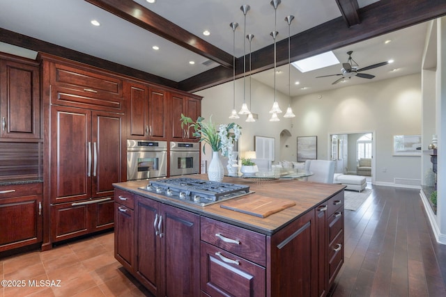 3750 E Sumo Quinto, Tucson, AZ 85718 - kitchen featuring appliances with stainless steel finishes, beamed ceiling, ceiling fan, a towering ceiling, and a center island