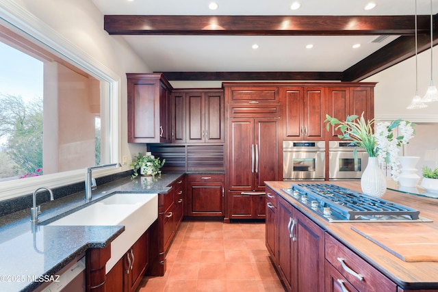 3750 E Sumo Quinto, Tucson, AZ 85718 - kitchen featuring stainless steel gas stovetop, beamed ceiling, paneled fridge, hanging light fixtures, and a sink