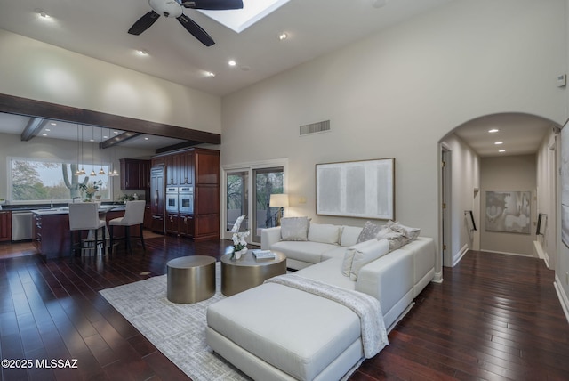 3750 E Sumo Quinto, Tucson, AZ 85718 - living room with a high ceiling, ceiling fan, arched walkways, dark wood-style floors, and a skylight