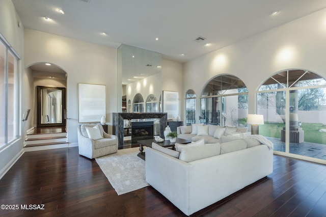 3750 E Sumo Quinto, Tucson, AZ 85718 - living area with dark wood-style floors, a fireplace, arched walkways, and recessed lighting