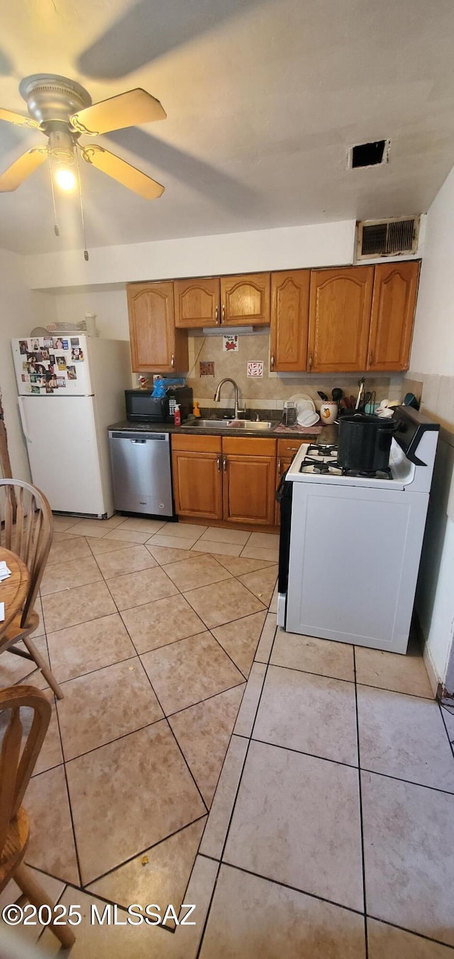 626 W Santa Paula St, Tucson, AZ 85706 - kitchen with white appliances, a sink, dark countertops, brown cabinets, and a ceiling fan