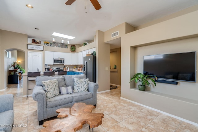 7511 W Sweet River Rd, Tucson, AZ 85743 - living room with light tile patterned floors, arched walkways, ceiling fan, and baseboards
