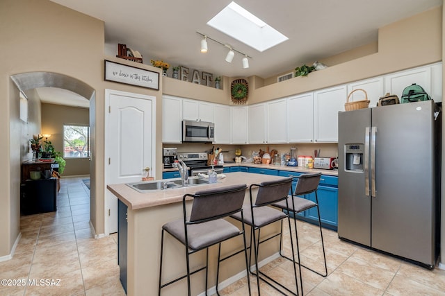 7511 W Sweet River Rd, Tucson, AZ 85743 - kitchen featuring stainless steel appliances, a sink, a skylight, white cabinetry, and light tile patterned floors