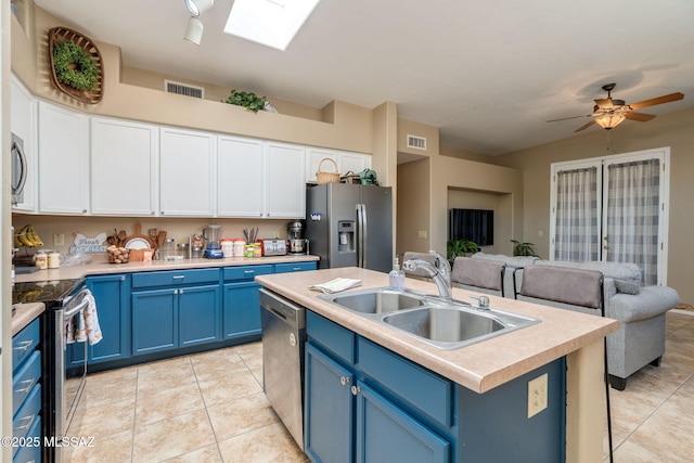 7511 W Sweet River Rd, Tucson, AZ 85743 - kitchen featuring appliances with stainless steel finishes, blue cabinetry, a sink, light tile patterned flooring, and open floor plan