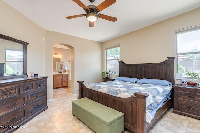 7511 W Sweet River Rd, Tucson, AZ 85743 - bedroom featuring arched walkways, connected bathroom, ceiling fan, and light tile patterned floors