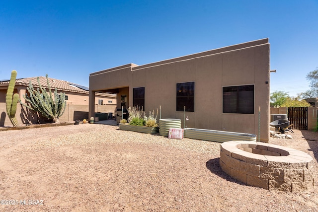 7511 W Sweet River Rd, Tucson, AZ 85743 - back of property with a fire pit, stucco siding, and a patio