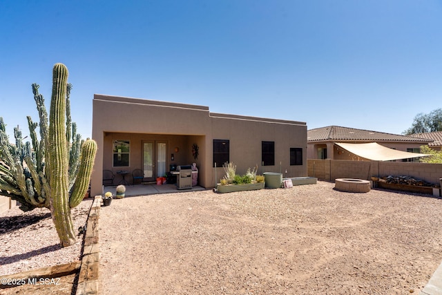 7511 W Sweet River Rd, Tucson, AZ 85743 - rear view of house featuring a patio, stucco siding, an outdoor fire pit, and a fenced backyard