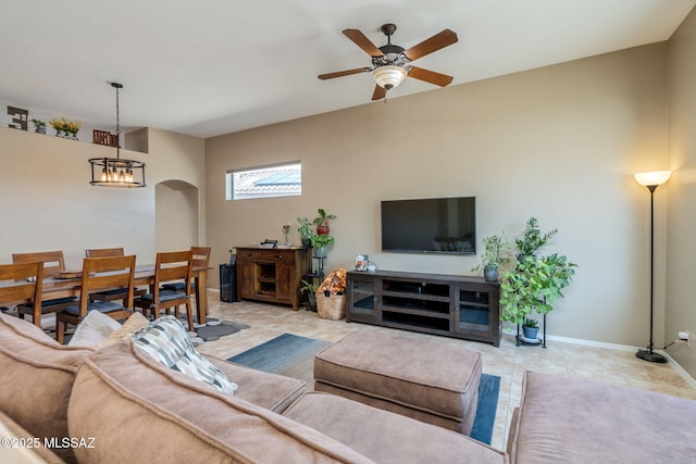 7511 W Sweet River Rd, Tucson, AZ 85743 - living room featuring arched walkways, ceiling fan, tile patterned floors, a chandelier, and baseboards