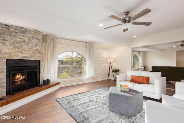 8628 N Placita Del Cardo, Tucson, AZ 85704 - living room featuring a ceiling fan, a large fireplace, baseboards, wood finished floors, and recessed lighting