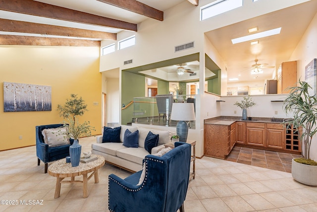 1900 E Campbell Ter, Tucson, AZ 85718 - living area featuring ceiling fan, a towering ceiling, a skylight, plenty of natural light, and beam ceiling