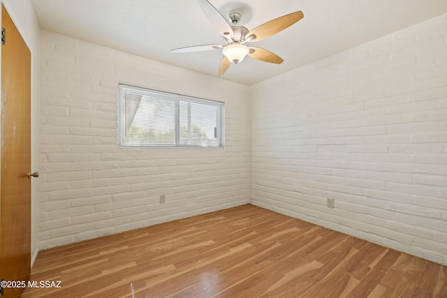 1716 S Sleepy Hollow Ave, Tucson, AZ 85710 - spare room featuring ceiling fan, wood finished floors, and brick wall